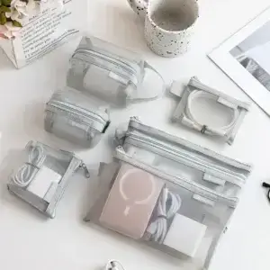 Grey mesh travel organizer pouches holding cables chargers and small electronic accessories