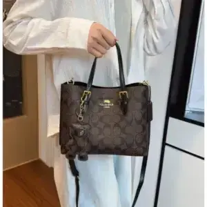 Person in a light shirt holding a brown printed tote bag by its dark handles