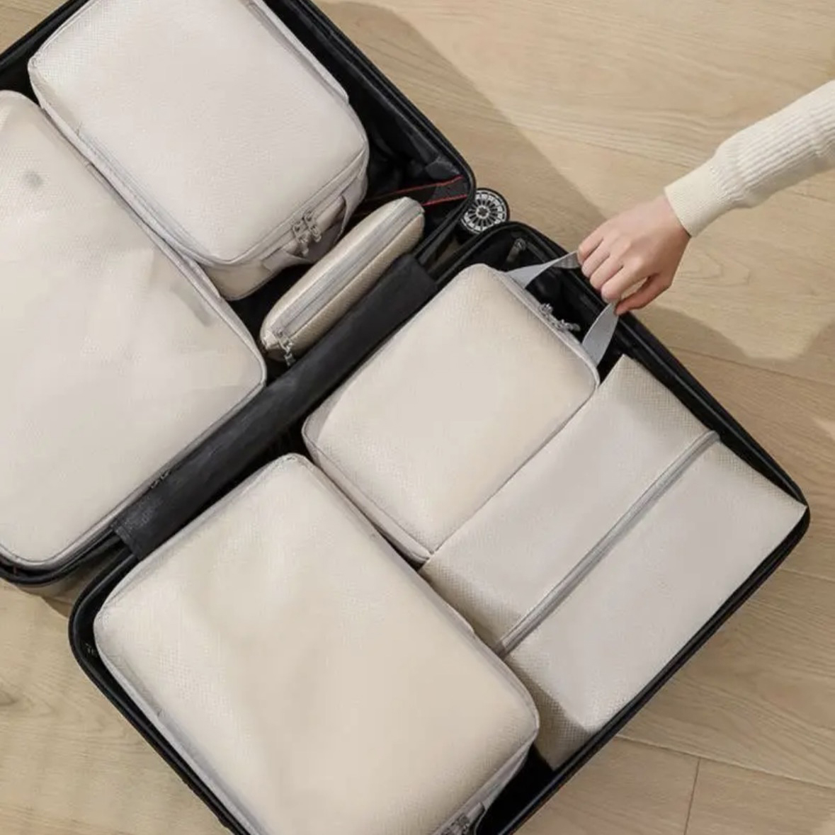 Ivory packing cubes fitted into both sides of a suitcase